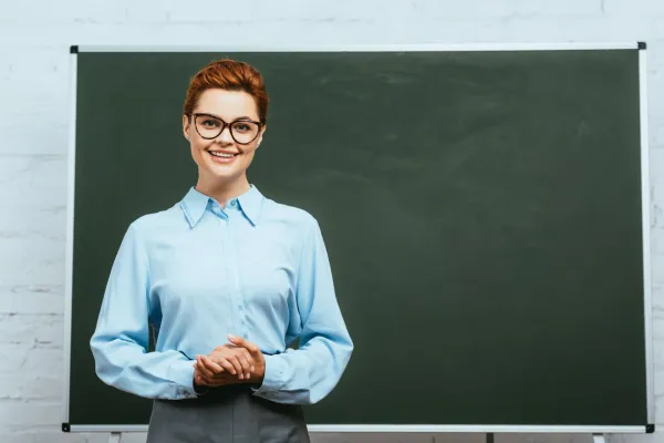 happy-teacher-in-eyeglasses-looking-at-camera-whil-2026-01-05-23-58-04-utc-697b8c494141d
